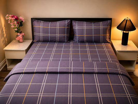 Bed with purple plaid bedding in a bedroom setting with nightstands and a lamp.