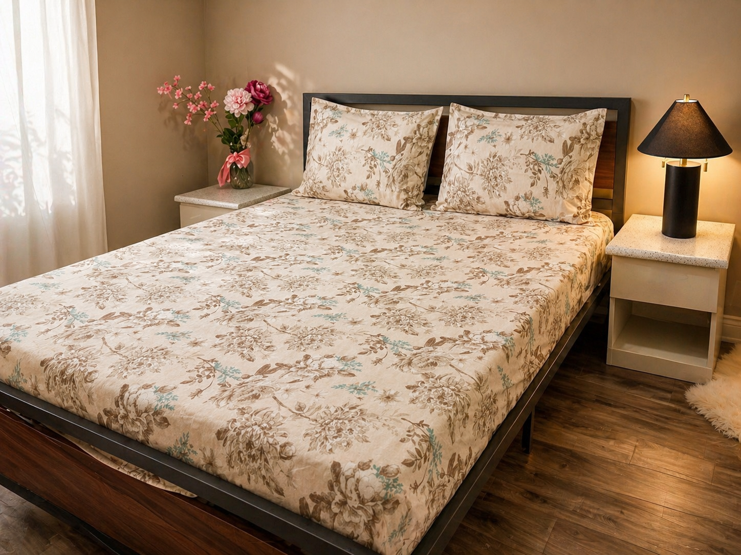 Bedroom with floral bedspread, nightstands, and a lamp.