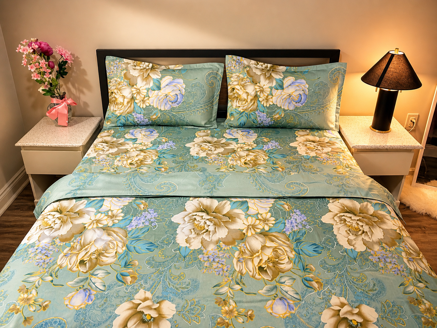 Floral bedding set on a bed with matching pillows, nightstands, and lamp.