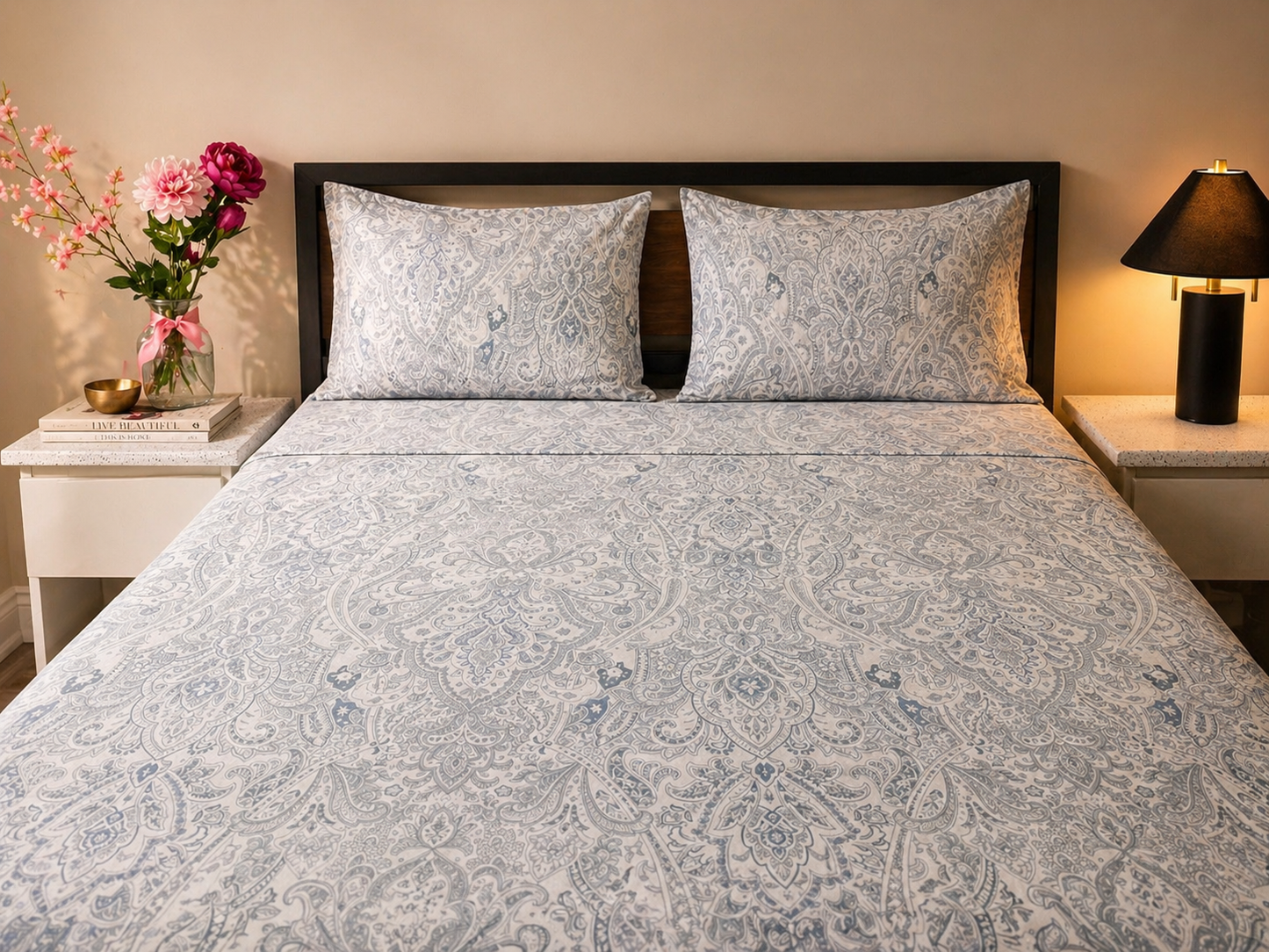 100% Cotton bedsheet on queen bed with patterned bedding, pillows, and a vase of flowers on a nightstand