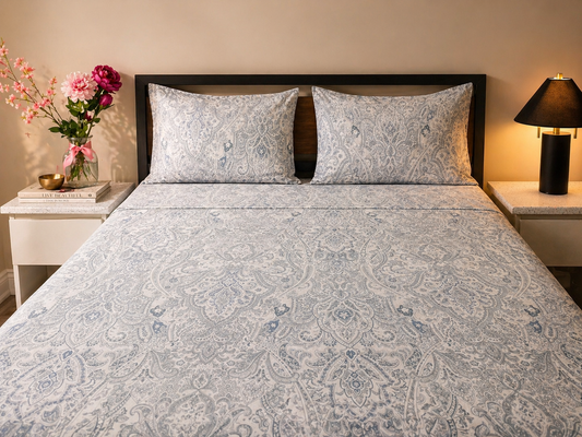 100% Cotton bedsheet on queen bed with patterned bedding, pillows, and a vase of flowers on a nightstand